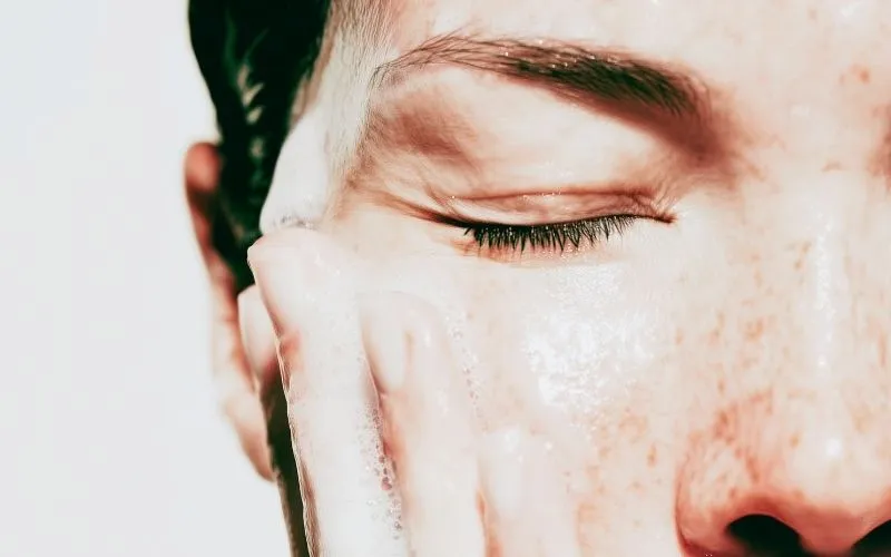 femme qui nettoie son visage avec un nettoyant doux