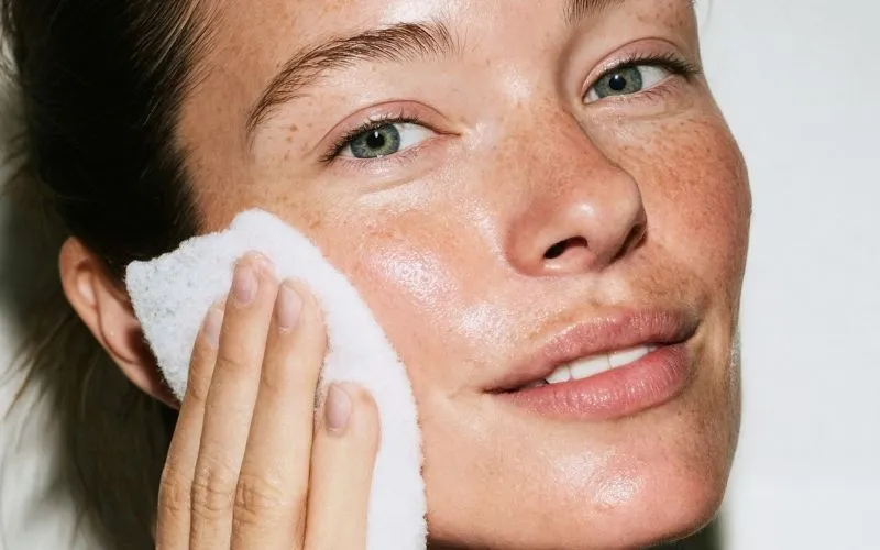 femme qui rince son visage avec une lingette.