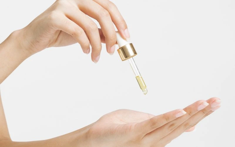 Femme qui prélève un sérum dans le creux de sa main