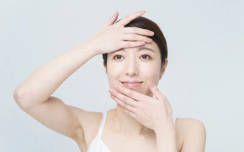 femme qui applique un sérum ou une crème sur son visage